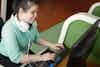 A young blind woman uses a Braille keyboard to navigate a website.