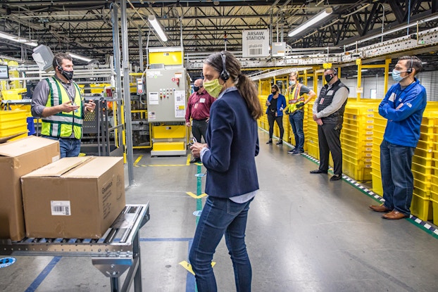 amazon employees working socially distanced in fulfillment center