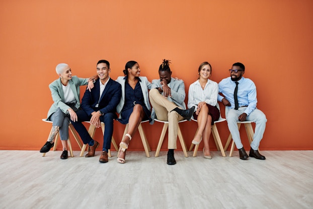 Row of job candidates sitting in a row smiling and laughing.
