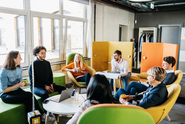 Group of employees sitting in a circle for a brainstorming session.
