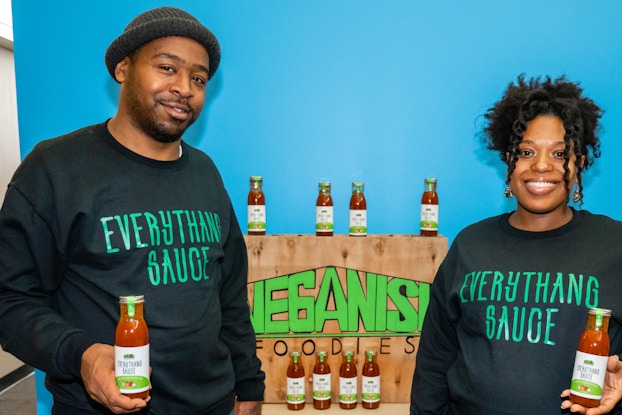 India Russell and Lamont Stuckey, owners of Everythang Sauce, holding bottles of their sauce.