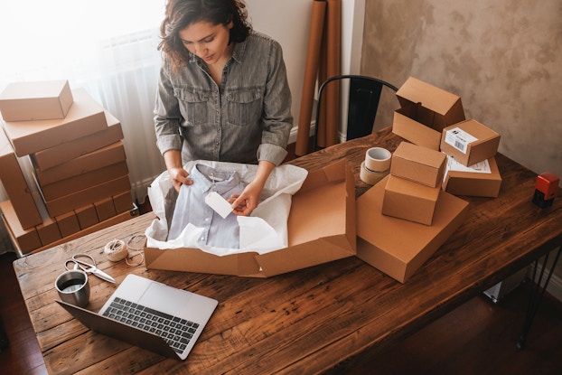 Small business owner packaging up a shirt.