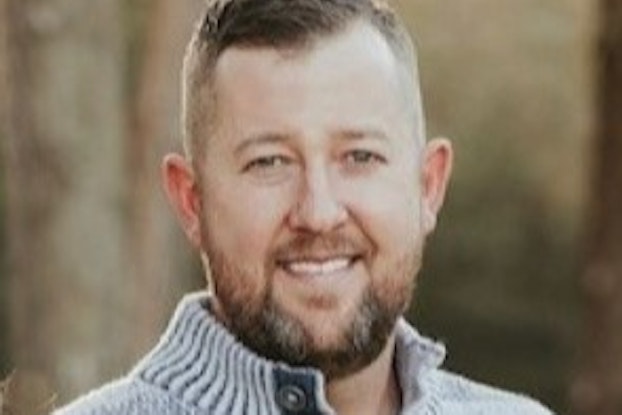 A headshot of Henry Wall, a Multi-owner of Re-Bath franchises. Henry is a smiling white man with brown hair and a slightly greying brown beard. He is wearing a light gray sweater.