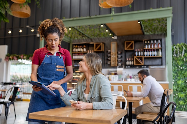 Customer and employee in a cafe using an iPad.