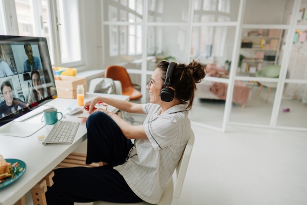 Woman working on computer on a video call in her house.