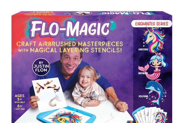 A box of Flo-magic's airbrushing craft kit. This box is for Flo-Magic's Enchanted series. The box is purple and bears a picture of Flo-Magic's creator, Justin Flom, at a table with a little blonde-haired girl. Flom is holding a stencil of a unicorn's mane. On the table in front of Flom is the finished stenciled drawing of a golden unicorn with a multicolored mane. Above the photo is the Flo-Magic logo and the caption "CRAFT AIRBRUSHED MASTERPIECES WITH MAGICLA LAYERING STENCILS!" On the right side of the boxes are examples of drawings you can make with the stencils, including a unicorn, a mermaid, and a dolphin.
